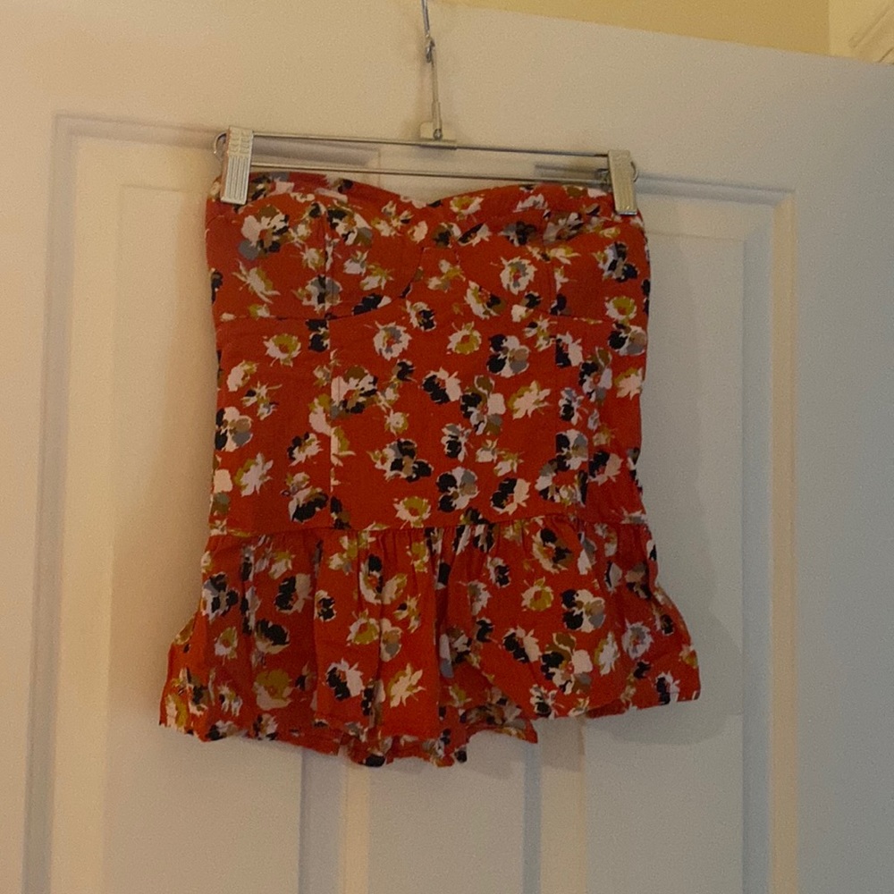 Cute strapless top with corset-like look with frills and cute flower design.